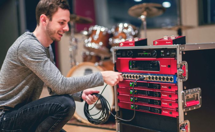 Luke Matyas, a student at the Music Technology program at Capital University, interacts with a gear setup including RedNet components from Focusrite
